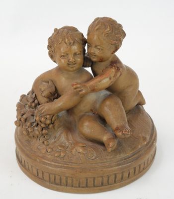 une petite statue représentant un garçon et une fille, posée sur une assiette