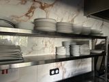 de nombreuses assiettes et casseroles empilées sur une étagère dans une cuisine