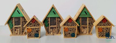 four small wooden houses that are lined up on a table