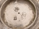 a close up view of a silver vase with writing on it
