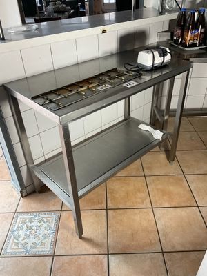 tiled floor in a restaurant kitchen with stainless steel table and appliances