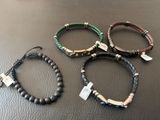 trois bracelets ornés d'une croix, posés sur une table