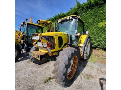 un gros plan d'un tracteur garé sur un parking avec d'autres tracteurs
