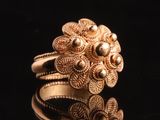 gros plan d'une bague en or sur une surface noire