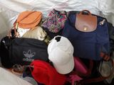a bag of clothes and a hat sitting on a bed