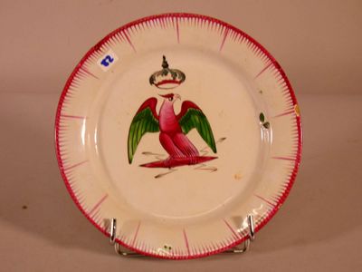 a red and white plate with a bird painted on it