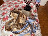 un petit enfant allongé sur un lit, recouvert d'une couverture à motif léopard
