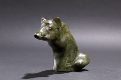 statue of a bear sitting on a gray surface