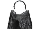 un sac à main noir muni d'une poignée en bambou sur fond blanc