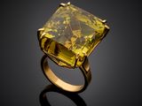 a yellow diamond ring on a black surface