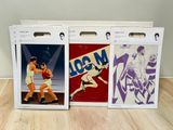 three boxes of various sports posters on a wooden table