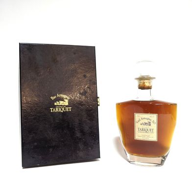 une vieille bouteille de whisky posée à côté d'une boîte noire