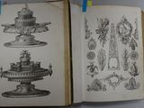 two open books with drawings on them on a table