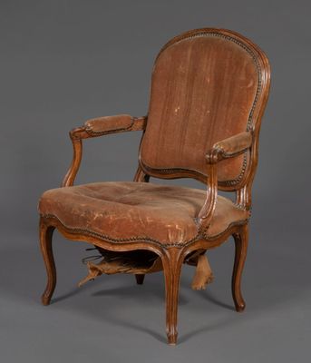 une vieille chaise en bois avec une assise rembourrée marron