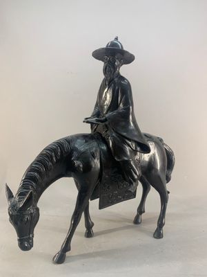 statue of a man riding a horse with a hat on his head