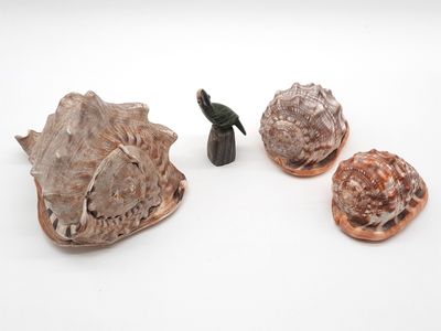 une petite figurine représentant un oiseau perché sur un coquillage
