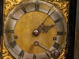 a black and gold clock with roman numerals on it