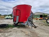 a red grainer that is sitting in the dirt