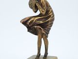 bronze statue of a woman sitting on a marble base