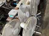 de nombreux ventilateurs posés sur une table dans une pièce