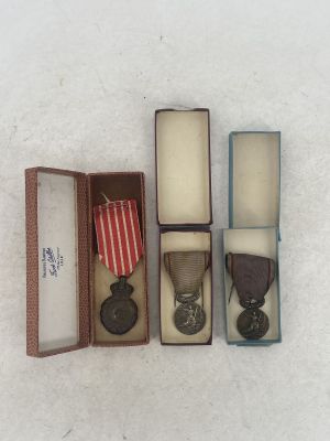 three medals are in a box on a white surface