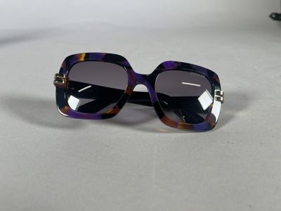 purple and black sunglasses on a table with a white background