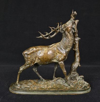 bronze sculpture of a stag standing next to a tree on a black background