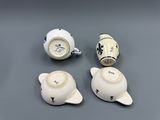 three white and blue teapots and a teapot on a gray surface