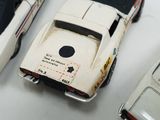 several toy cars are lined up on a white surface