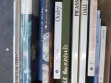 de nombreux livres qui se trouvent dans une boîte posée par terre