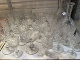a lot of wine glasses and a bottle on a table