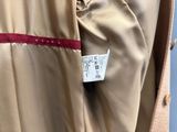 le dos d'un manteau beige orné d'une bande rouge
