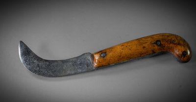 a close up of a knife with a wooden handle on a table