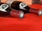 two bottles of wine sitting on a red cloth