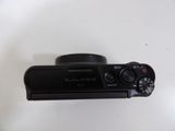 a black camera sitting on a white surface