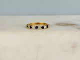 une image représentant une bague en or sertie de diamants noirs et blancs