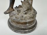 a statue of a man holding a fish on top of a pedestal