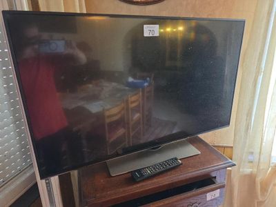 une télévision à écran plat posée sur une table en bois