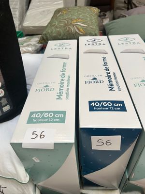 three boxes of toothpaste sitting on top of a bed next to a bottle of toothpaste