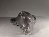 a statue of a dog laying down on the floor