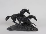 statue of two horses running on a rock on a white background