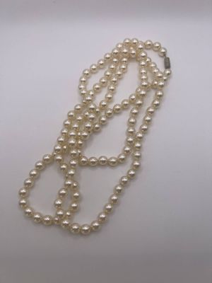 gros plan d'un collier de perles blanches sur une surface blanche
