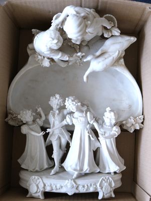 une figurine blanche dans une boîte décorée d'anges