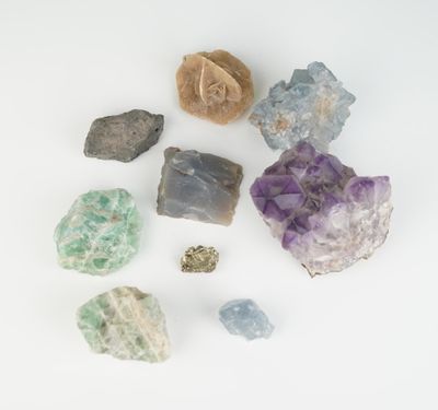 différentes sortes de roches et de cristaux sur une surface blanche