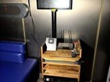 une télévision posée sur un meuble à côté d'un fauteuil bleu dans une pièce