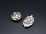 two silver lockes sitting on top of a black surface
