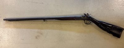 un vieux fusil est accroché au mur à côté d'un mur