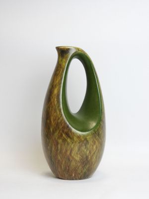 a green vase that is sitting on a white surface