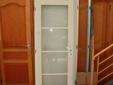 a glass door in the middle of a room with wooden cabinets