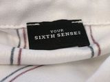 the label on the back of a white shirt reads, ' your sixth sense '